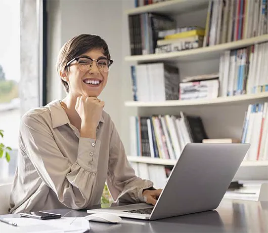 Alianza para la Inclusión Laboral, mujer sonriedo frente a un computador