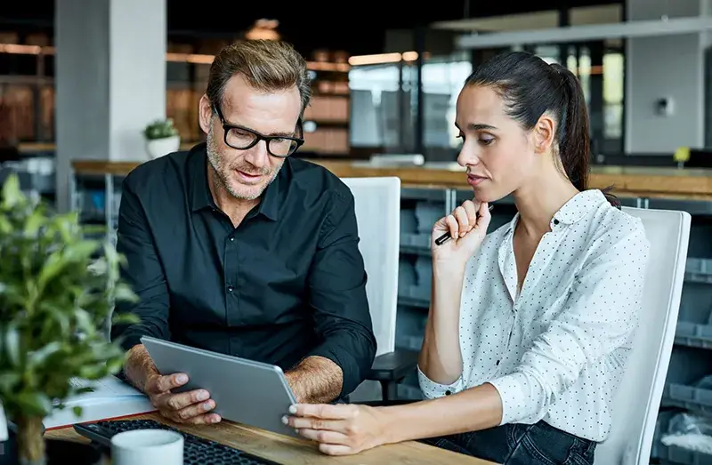 dos emprendedores conversando mientras miran una tablet, ventures capital consorcio
