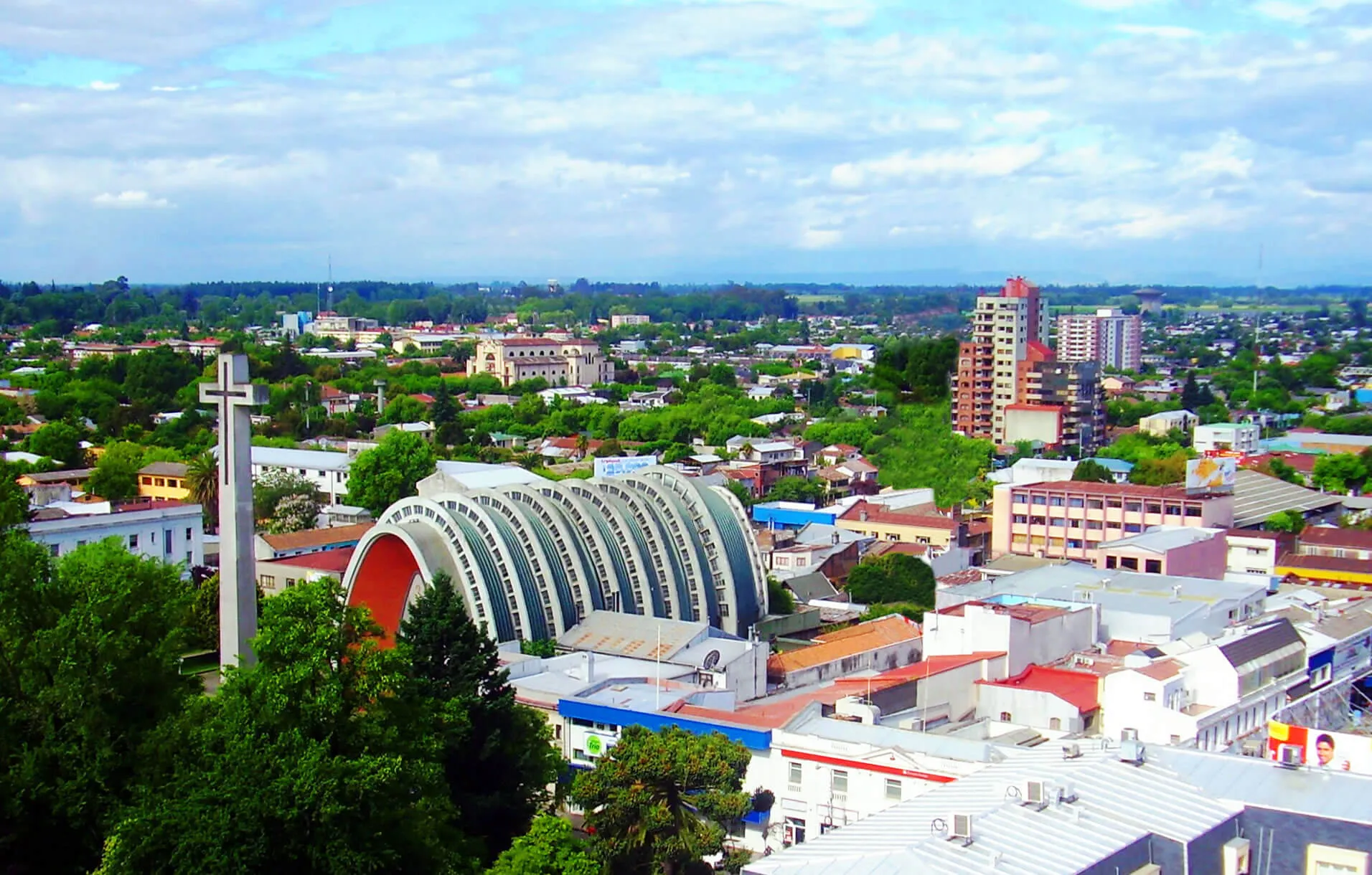 Chillán: vista urbana con la Catedral y su torre con cruz entre áreas verdes.